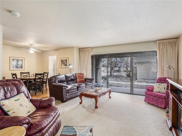 carpeted living room with ceiling fan and a textured ceiling