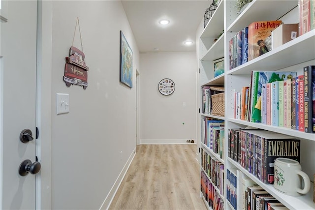 hall featuring recessed lighting, light wood-style flooring, and baseboards