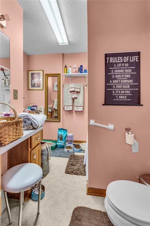 bathroom with toilet and a textured ceiling