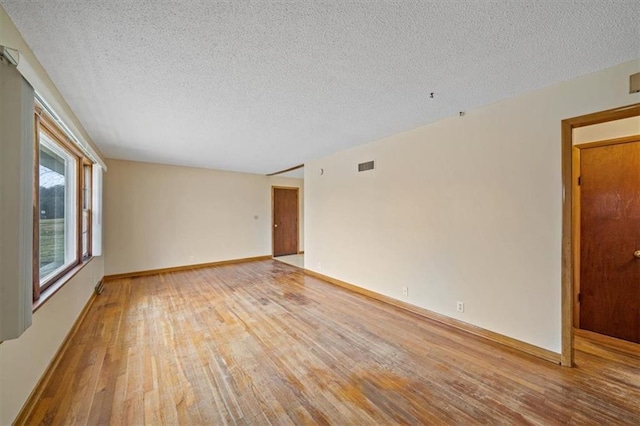 empty room featuring hardwood / wood-style flooring and a textured ceiling