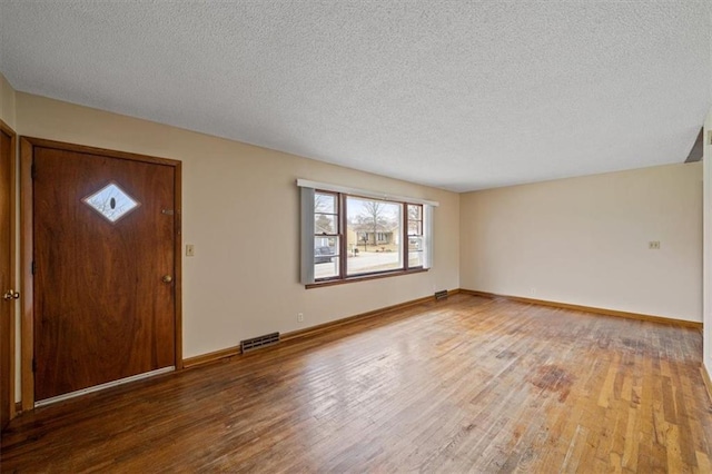 foyer entrance featuring hardwood / wood-style flooring and a textured ceiling