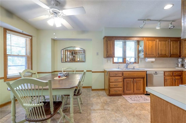 3812 SW Windemere Dr, Lees Summit, MO 64082 - kitchen with stainless steel dishwasher, brown cabinetry, a ceiling fan, decorative backsplash, and a textured ceiling