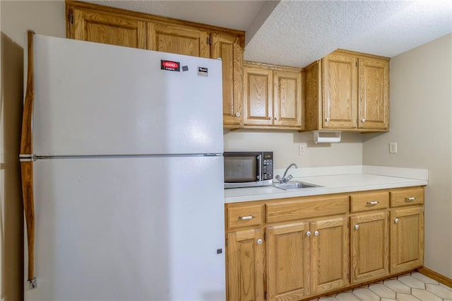 3812 SW Windemere Dr, Lees Summit, MO 64082 - kitchen with freestanding refrigerator, stainless steel microwave, light countertops, a textured ceiling, and light tile patterned floors