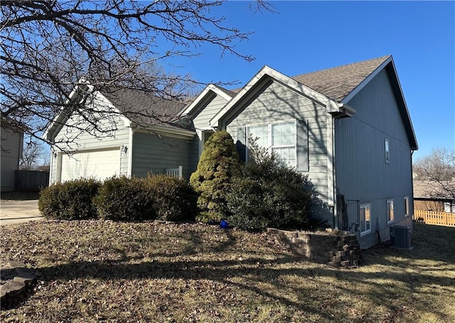 view of side of property with a garage and central AC unit