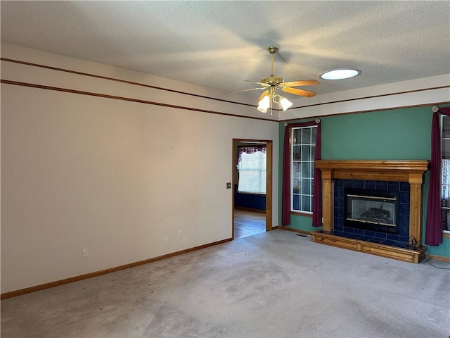 unfurnished living room featuring ceiling fan, a fireplace, carpet, and a textured ceiling