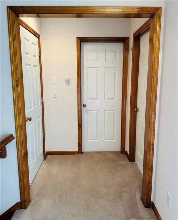 hall with light colored carpet