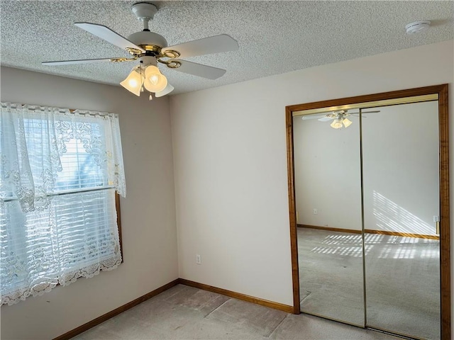 carpeted spare room featuring ceiling fan and a textured ceiling