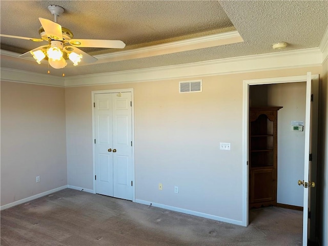 unfurnished bedroom featuring ornamental molding, a raised ceiling, and carpet floors