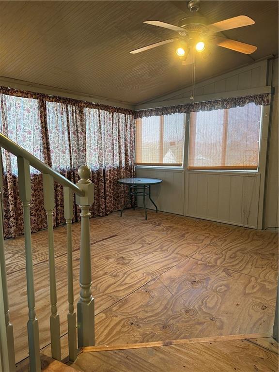 unfurnished sunroom with lofted ceiling and ceiling fan