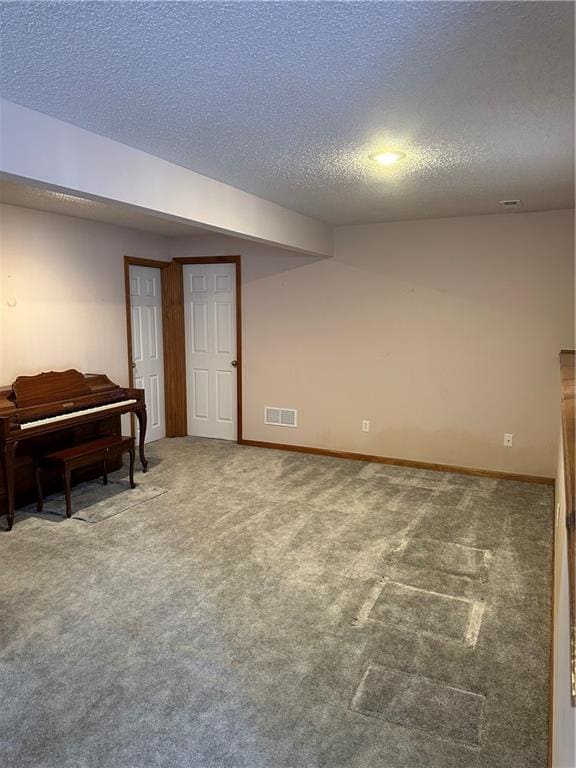 basement featuring a textured ceiling and carpet