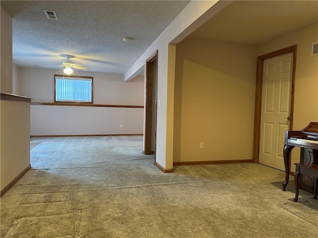 carpeted spare room featuring ceiling fan and a textured ceiling