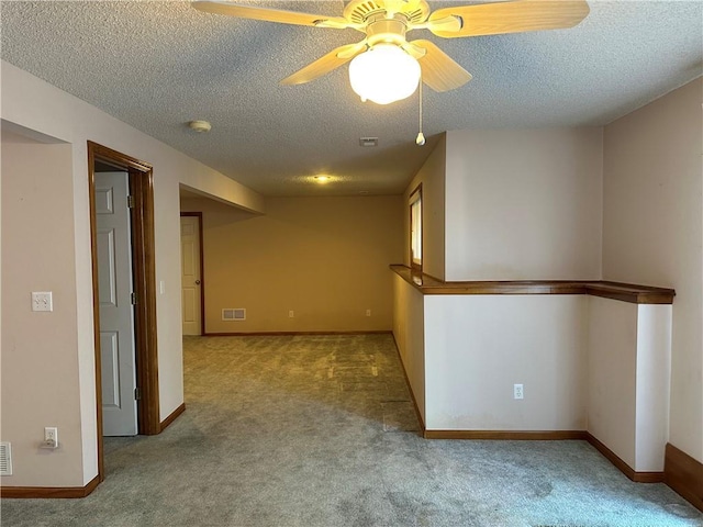 carpeted spare room with ceiling fan and a textured ceiling