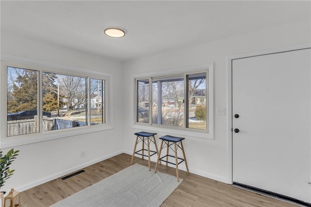 interior space with wood finished floors, visible vents, and baseboards