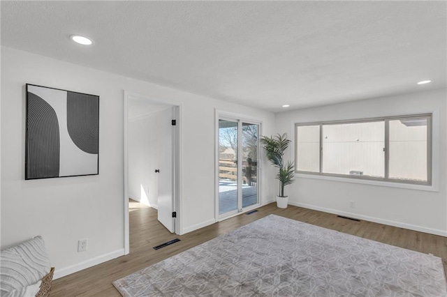 unfurnished room featuring recessed lighting, visible vents, baseboards, and wood finished floors