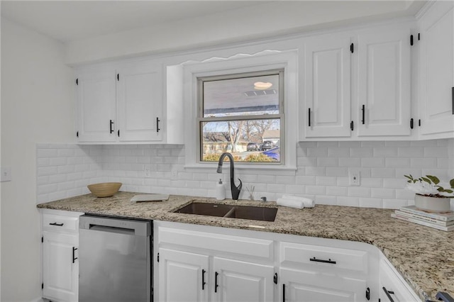 kitchen featuring decorative backsplash, white cabinetry, dishwasher, and a sink