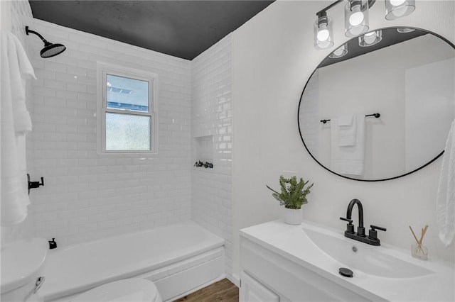 bathroom featuring wood finished floors, shower / washtub combination, a sink, and toilet