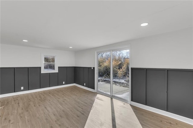 unfurnished room featuring recessed lighting, a wainscoted wall, and wood finished floors