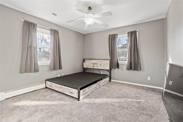 unfurnished bedroom featuring ceiling fan, carpet flooring, visible vents, baseboards, and baseboard heating