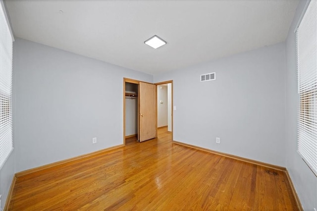 unfurnished bedroom with a closet and light hardwood / wood-style floors