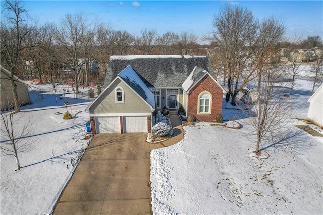 view of front of property featuring an attached garage, brick siding, a shingled roof, driveway, and stucco siding