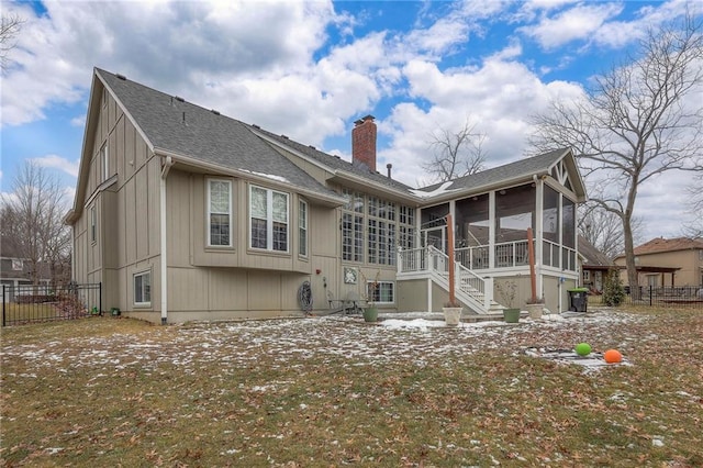 back of property featuring a sunroom, a chimney, roof with shingles, stairs, and fence