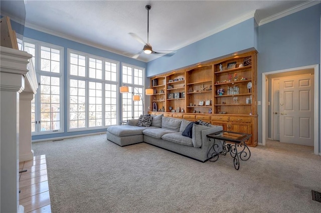 living area featuring ornamental molding, light colored carpet, and ceiling fan