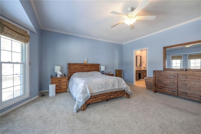 bedroom with baseboards, a ceiling fan, light colored carpet, ensuite bathroom, and crown molding