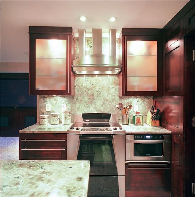 kitchen with light stone counters, range with electric cooktop, oven, decorative backsplash, and exhaust hood