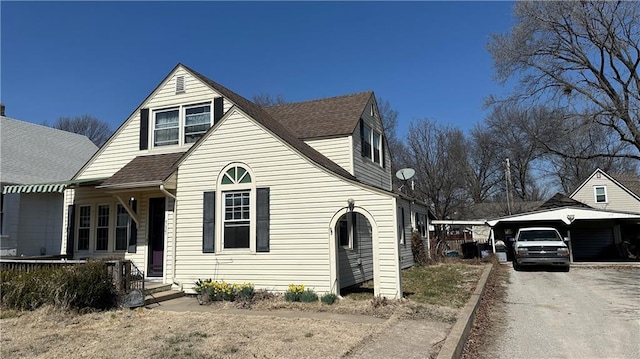 view of front of property with a carport and a shingled roof