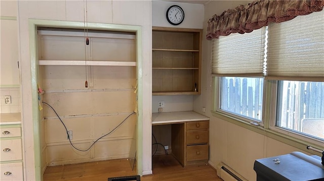 unfurnished office featuring visible vents, light wood finished floors, and a baseboard radiator