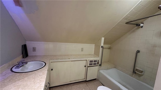 bathroom with vanity,  shower combination, and lofted ceiling