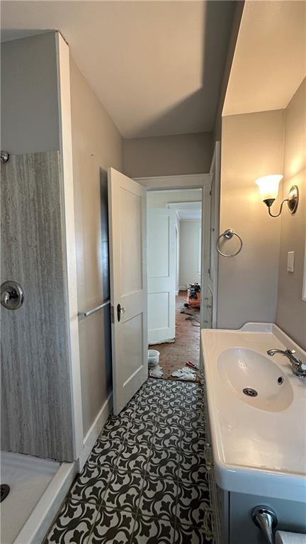 bathroom featuring baseboards, vanity, and a shower stall