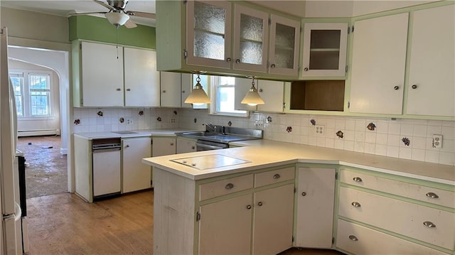 kitchen with decorative backsplash, a peninsula, light countertops, a baseboard radiator, and ceiling fan