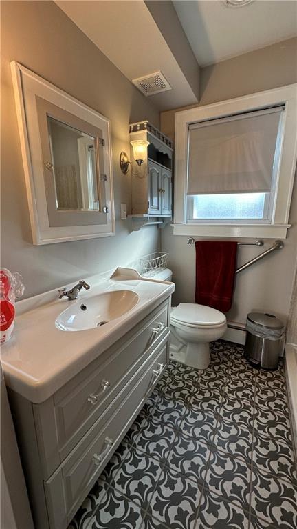 bathroom featuring vanity, visible vents, a baseboard radiator, tile patterned floors, and toilet