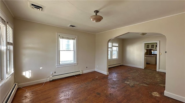 empty room featuring a wealth of natural light, visible vents, arched walkways, and baseboard heating