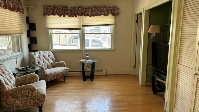 sitting room with light wood-style floors and baseboard heating