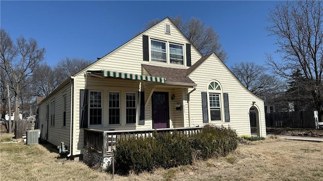 bungalow-style house featuring a porch, fence, central AC unit, and a shingled roof