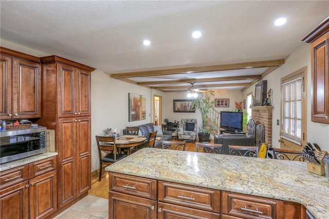 10111 E 86th Ter, Raytown, MO 64138 - kitchen featuring ceiling fan, light stone countertops, a textured ceiling, and beam ceiling