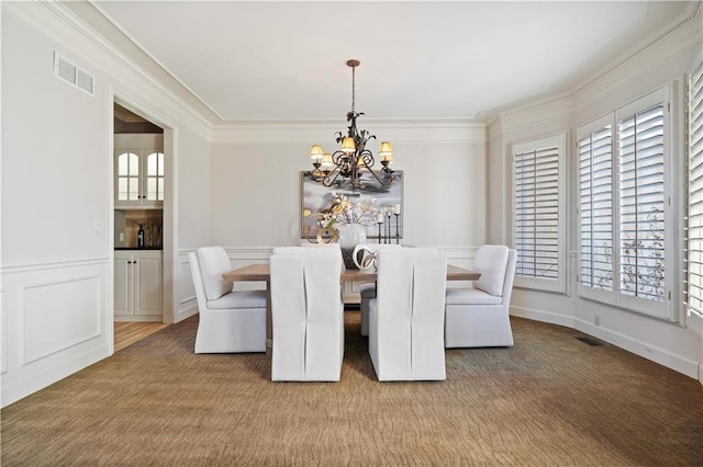 dining area with ornamental molding, a wealth of natural light, and an inviting chandelier