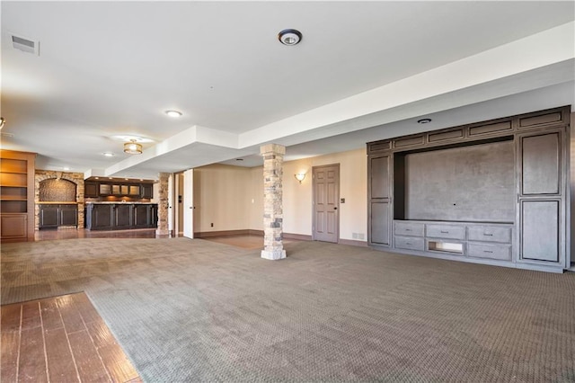 unfurnished living room featuring carpet floors, visible vents, decorative columns, and baseboards