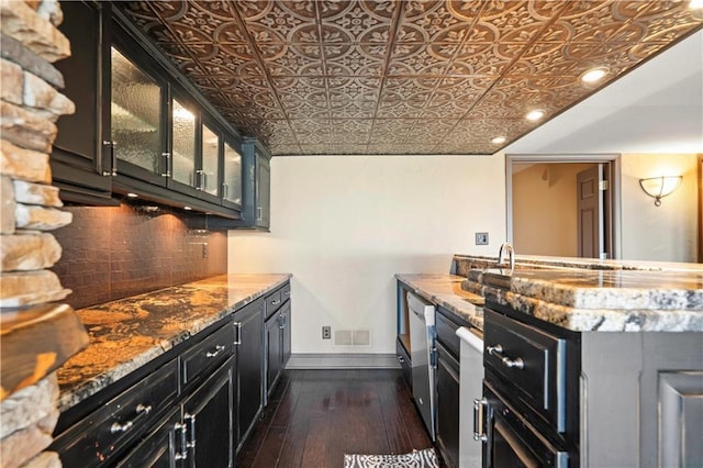 kitchen with baseboards, an ornate ceiling, dark wood-type flooring, dark cabinetry, and backsplash