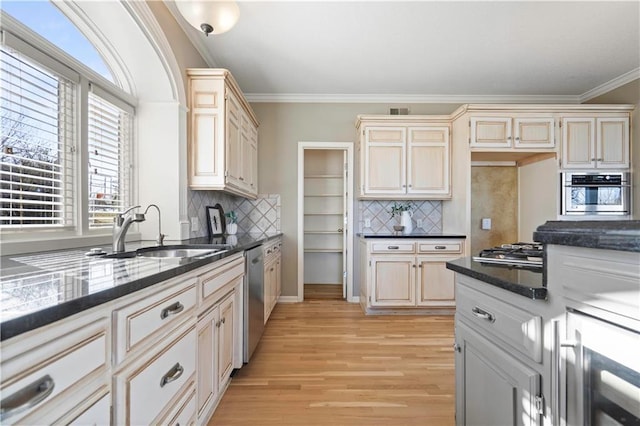 kitchen featuring crown molding, visible vents, appliances with stainless steel finishes, light wood-style floors, and a sink