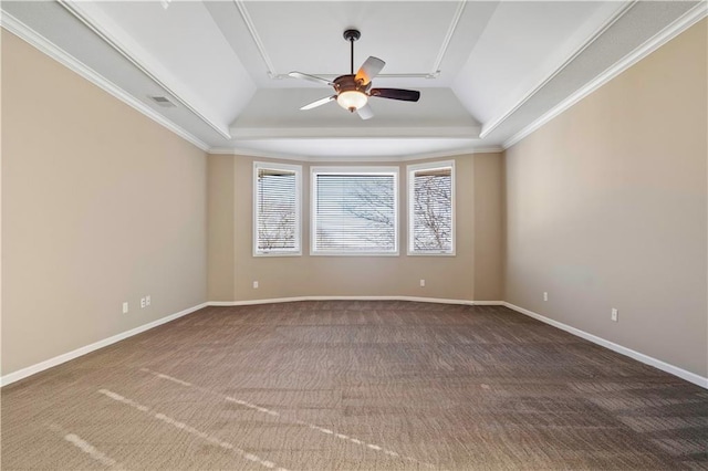 carpeted spare room with a ceiling fan, a tray ceiling, crown molding, and baseboards