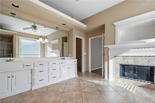 bathroom featuring ceiling fan with notable chandelier, double vanity, and a sink