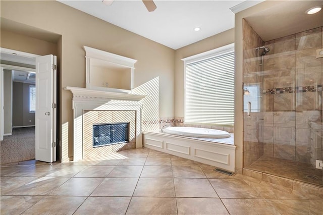 bathroom with plenty of natural light, a stall shower, a garden tub, and a fireplace