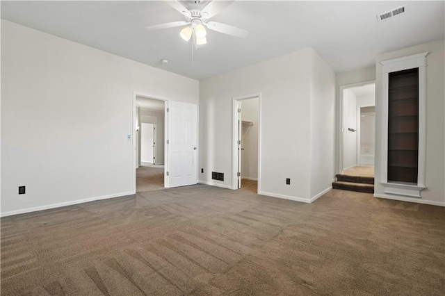 unfurnished bedroom with carpet, visible vents, and baseboards