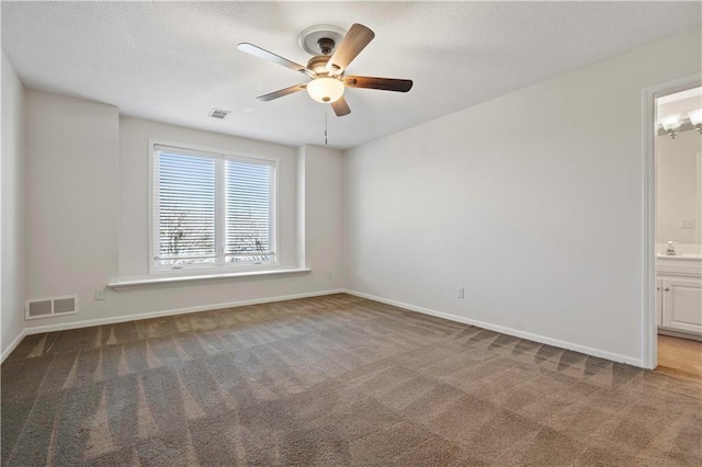 carpeted empty room with ceiling fan, a sink, visible vents, and baseboards