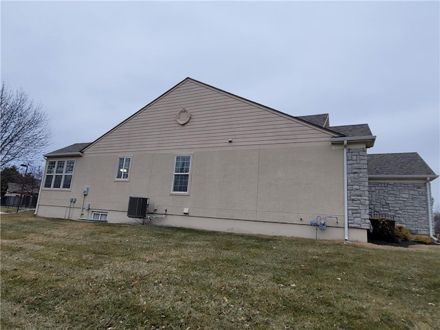 view of home's exterior with central AC and a lawn