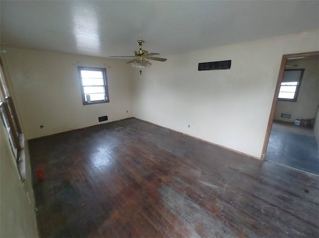 empty room with dark wood finished floors and ceiling fan