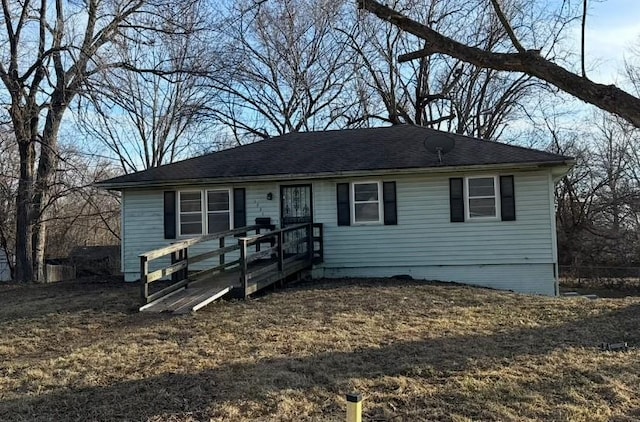 view of front of property featuring a shingled roof and a wooden deck